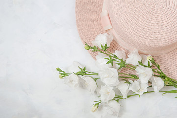 summer composition - hat, bouquet of white flowers on a white background. The concept of summer, warmth, relaxation.