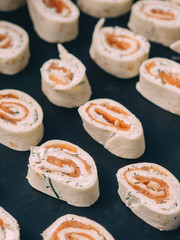 Rolls of thin pancakes with smoked salmon, horseradish cream cheese
