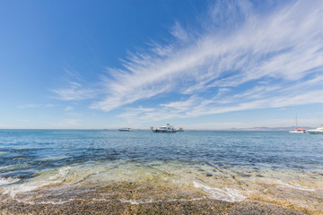 Yachts and small boats in the ocean near the shore