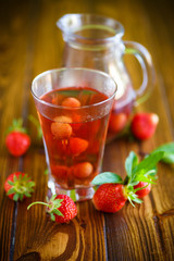 Sweet compote of ripe red strawberries in a glass decanter