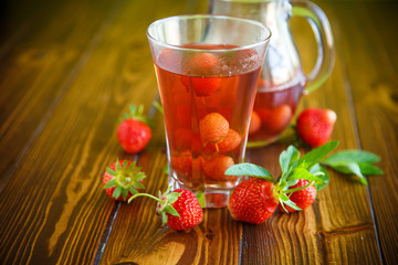 Sweet compote of ripe red strawberries in a glass decanter