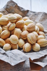 Russian dessert - nuts from short pastry with a filling of boiled condensed milk, with the addition of whole walnuts and hazelnuts