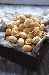 Russian dessert - nuts from short pastry with a filling of boiled condensed milk, with the addition of whole walnuts and hazelnuts