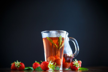 Sweet compote of ripe red strawberries in a glass decanter