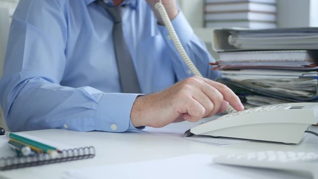 Businessperson in Office Room Using Landline Make a Phone Call