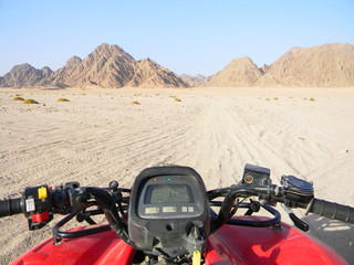 Quad bike in the desert race.  All terrain vehicle or quadricycle view in the desert road.