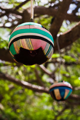 lámpara reciclada hecha con chanclas de colores colgad de un árbol