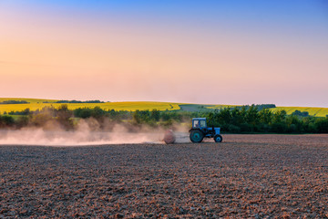 the tractor pulls the plow in the field