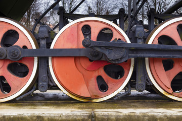 Close up of an old steam locomotive red wheels and gear