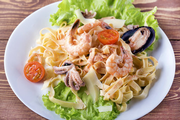 Fettuccine pasta with shrimp, tomatoes and herbs.Italian cuisine. Top view