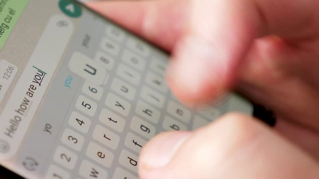 Close up man hands typing a text on the smartphone screen. He is chatting