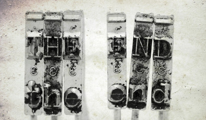 The words   THE END  with old typewriter hammers  with old paper background