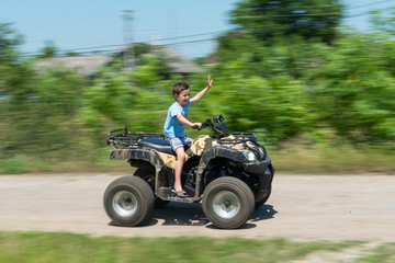 Fototapeta na wymiar The boy is traveling on an ATV.