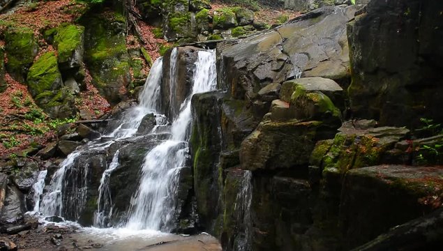 Waterfall Skakalo in deep forest. beautiful summer scenery of Carpathian nature. Wild place with huge mossy boulders. side view with polarizing effect