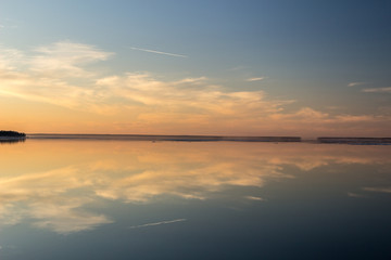 Sea surface with reflection of sky and clouds at sunset