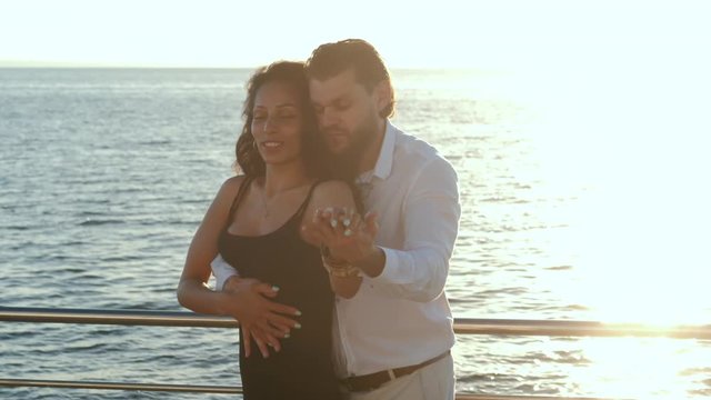 Energetic attractive young brazilian couple dancing latin Bachata near sea or ocean. Sunlight background. Summer time, romantic footage. Slow motion.