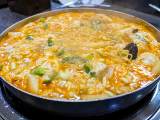 Cheesy Tokbokki korean traditional food on wood background close up.