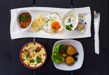 Traditional Arabic breakfast, lettuce, eggs, cheese, olives, and decorative vegetables, served on a plate, restaurant, service