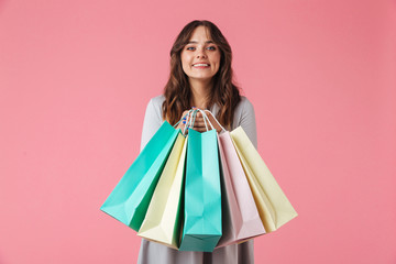 Happy young pretty woman shopaholic holding shopping bags.