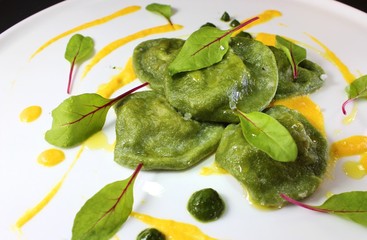 Spinach ravioli with mushroom duxelles served with pumpkin sauce and garnished with red vein sorrel