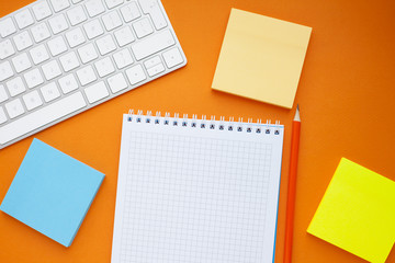 Set of colorful stickers, white keyboard, notebook and snacks. Office table, desk with different objects. Working process. Education, business concept.