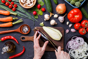Fototapeta na wymiar Photo on top of fresh vegetables, champignons, cutting board, oil, knife, eggplant, chef's hands