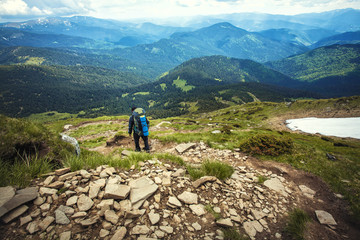 Fototapeta na wymiar A tourist walks along a mountain meandering trail