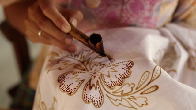 Detail of waxing the drawing to textile for making batik. Bali island.