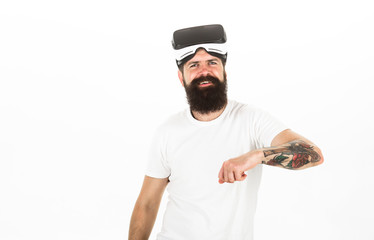 Man with beard and mustache holds VR glasses, white background. Hipster on smiling face use modern technologies for entertainment. VR technology concept. Guy with VR glasses or head mounted display