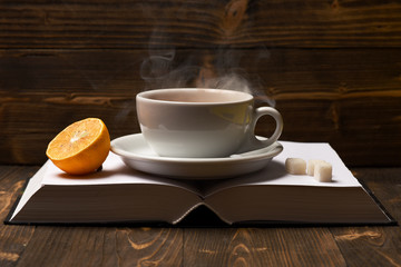 Tea cup with steam on blank book pages