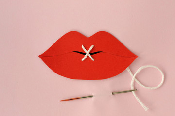 Paper lips cut-out sewn with white thread - Violence against women concept