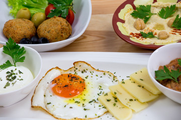 Traditional Arabic breakfast, lettuce, eggs, cheese, olives, and decorative vegetables, served on a plate, restaurant, service