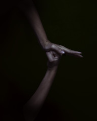 conceptual photography of two hands on black background