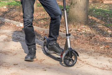 Obraz premium the boy on the scooter rides along the road, the bike path