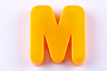 letter M uppercase alphabet isolated made of plastic on white background with shadows