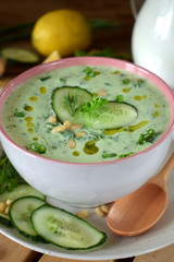 Cold soup Tarator with kefir, cucumbers and pine nuts in a ceramic tureen. Bulgarian cuisine meal