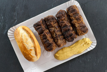 Delicious grilled minced meat rolls mici ori mititei traditional romanian and balkan dish served with mustard cardboard tradition fast food concept