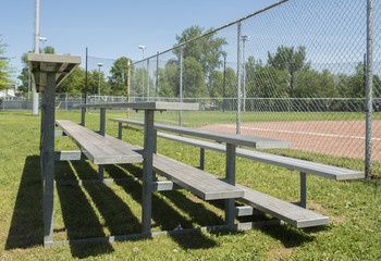 Bleachers are shown at a baseball diamond in a park