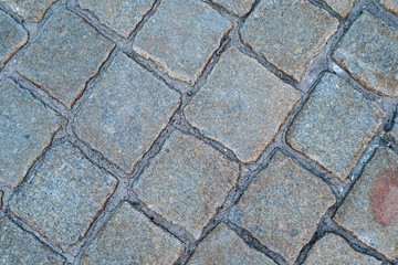 the texture of the old square stone tiles on the pavement