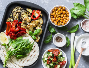Ingredients for cooking summer grilled garden vegetables and spicy chickpeas vegetarian tortillas on grey background, top view. Healthy food picnic concept