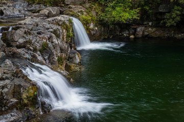 Waterfalls flow over rocks in the woods