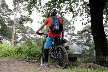 Mountainbiker macht Pause an einer Bank
