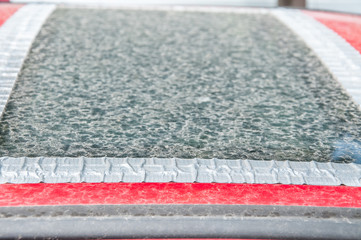 Damaged glass roof window or sunroof on the red car glued with duct tape to prevent water to come...