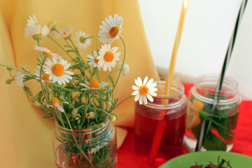 Summer concept with bright cocktails, fresh strawberry and camomile on red  bright background. Close up