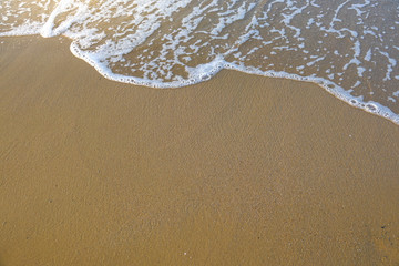 Soft beautiful ocean wave on sandy beach in the sunset. Crete, Greece.
