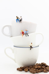 Miniature people : Business team sitting on cup of coffee and having a coffee break. Image use for business concept.