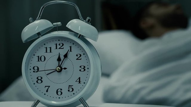 Healthy sleep of male, alarm clock standing on table near bed, time for relax