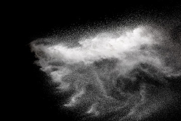 Freeze motion of white particles on black background. Abstract white dust explosion.