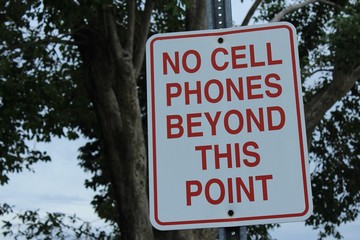 no cell phones beyond this point metal sign on post