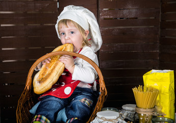 little boy in the cook's cap on the background of the products